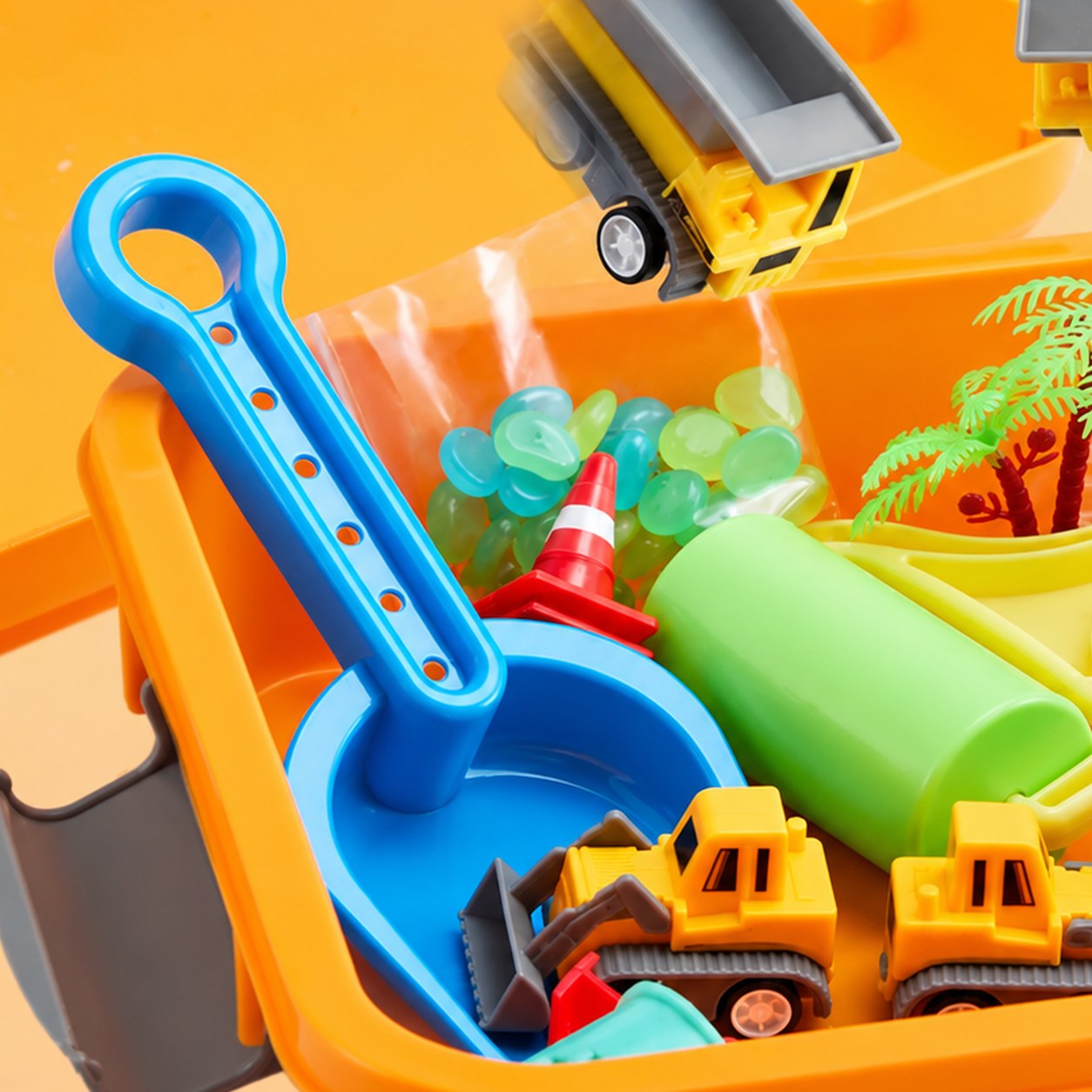 A blue shovel and a green roller tool in the orange bin