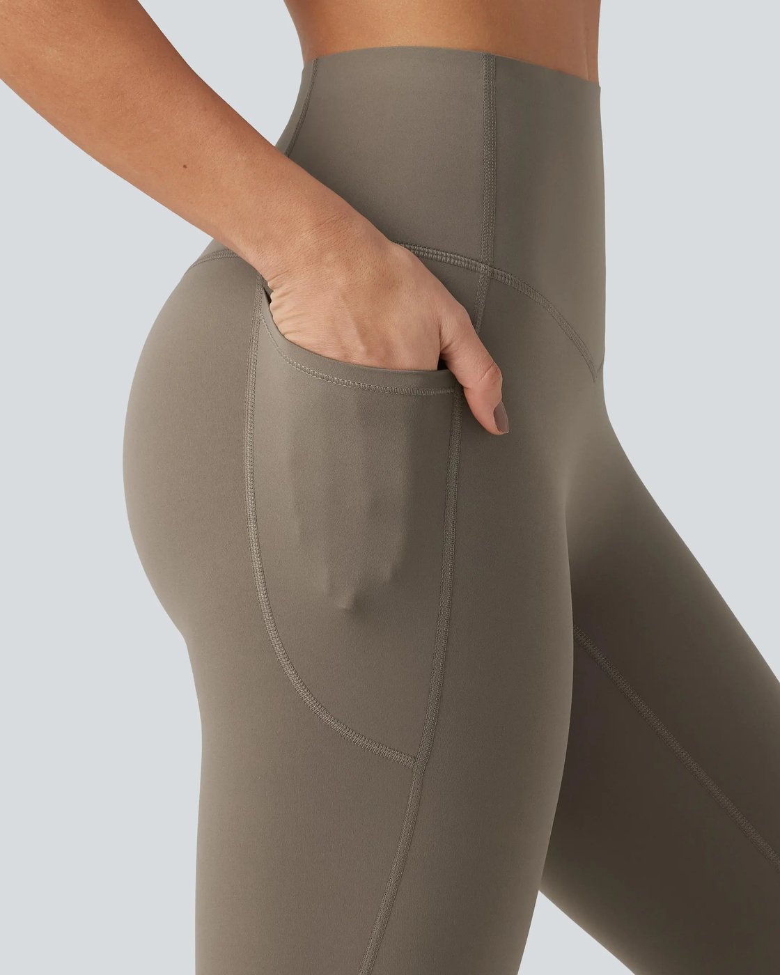 A hand sliding into the side pocket of the Pomence high waisted tummy control sculpt leggings