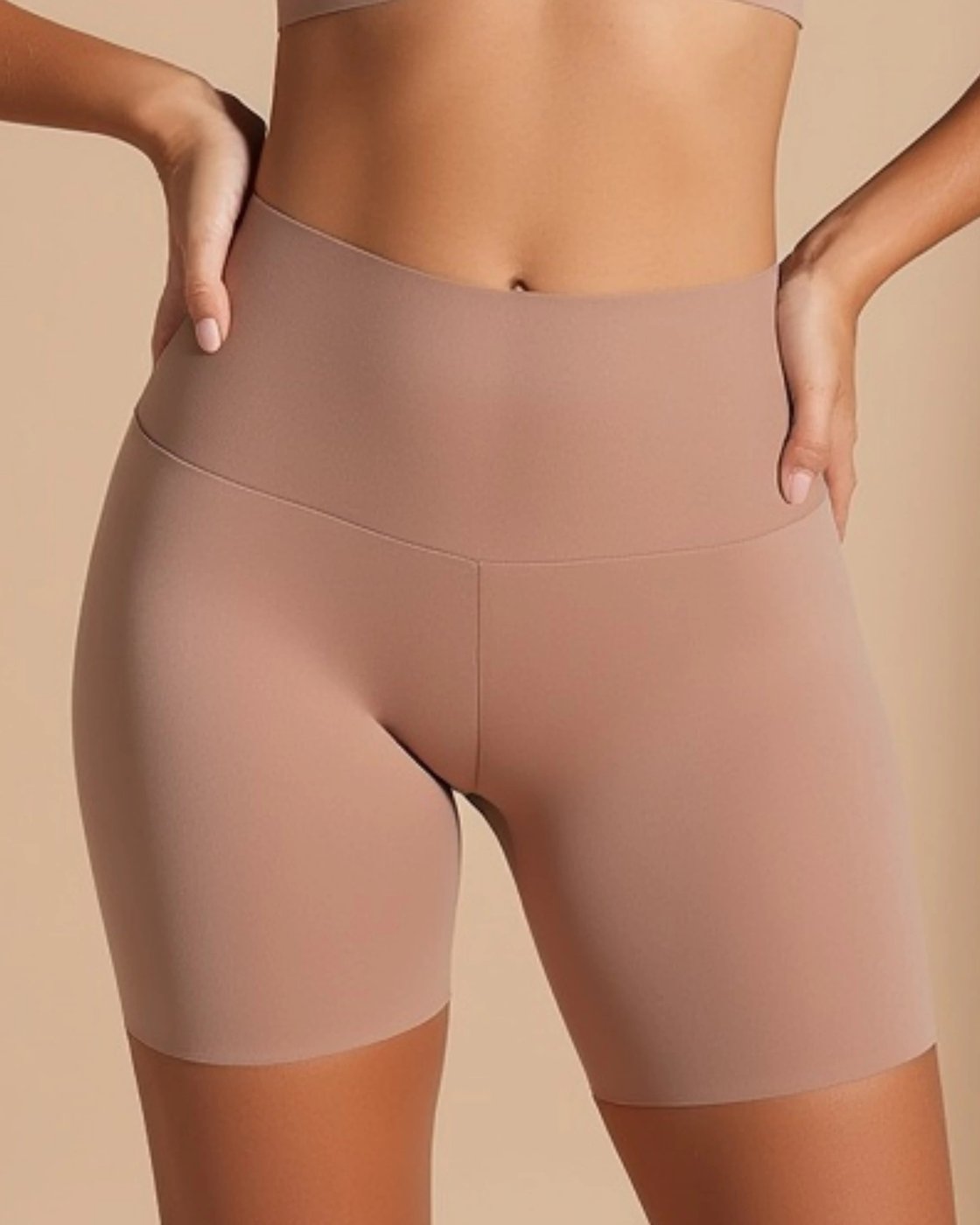 The Pomence Tuck-N-Lift Seamless Slip Short worn with hands on the hips, smooth from the waist to mid thigh