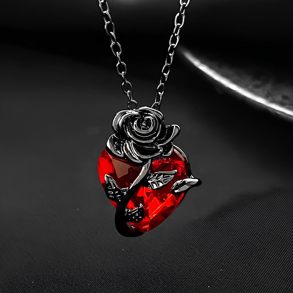 Pomence Blood Rose Necklace in Black, the faceted red crystal heart with the sculpted rose and stem, close up