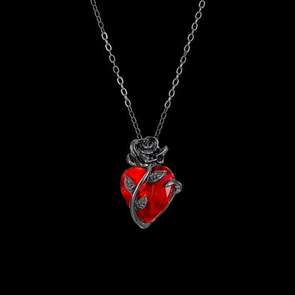 Pomence Blood Rose Necklace in Black hanging on its chain on a black background