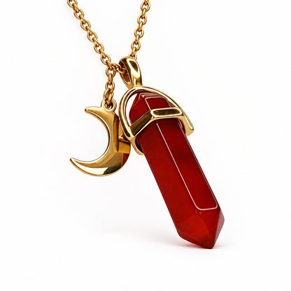 The gold Pomence Carnelian Attraction Necklace photographed alone, showing the carnelian point in its gold stirrup bail, the gold crescent moon charm and the gold chain