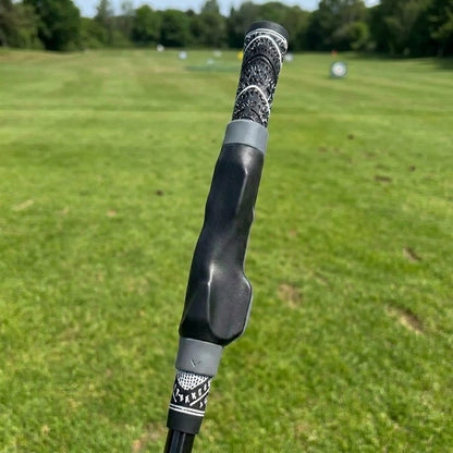Pomence Golf Grip Trainer with gray collars, clipped onto a golf club grip