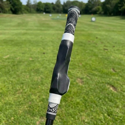 Pomence Golf Grip Trainer with white collars, clipped onto a golf club grip