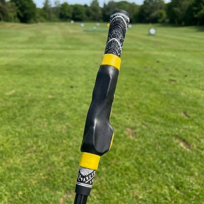 Pomence Golf Grip Trainer with yellow collars, clipped onto a golf club grip
