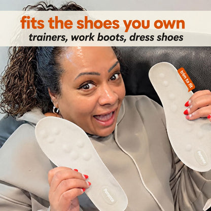 A customer holding a pair of Pomence Massage Insoles, both white cobblestone bases toward the camera