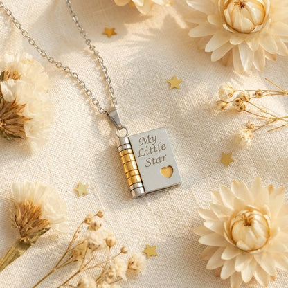 Pomence My Little Star Book Locket Necklace in Silver laid flat with dried flowers