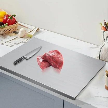 Pomence™ Stainless Steel Chopping Board. Raw steak resting on the board beside a chef knife