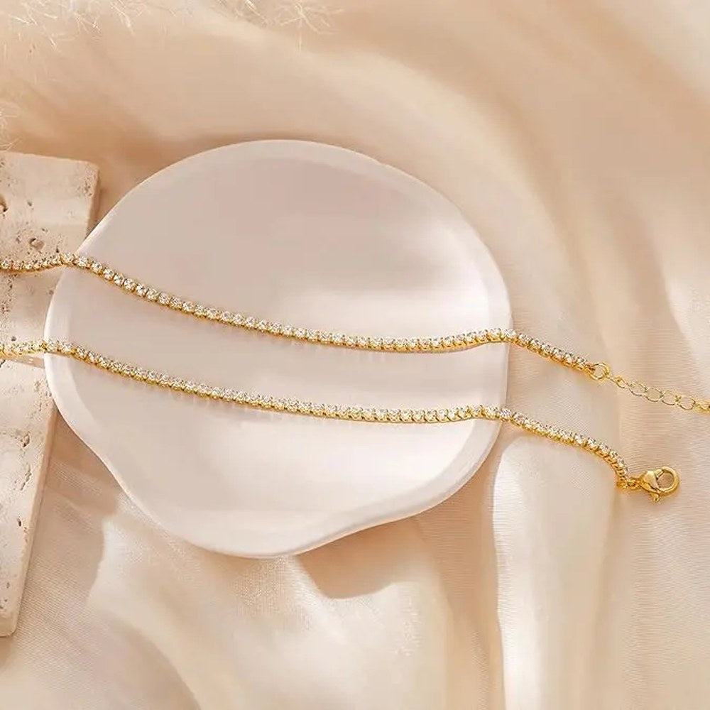 The Pomence Tennis Necklace in the gold plated colorway, the continuous row of 2mm round cubic zirconia stones and the lobster clasp