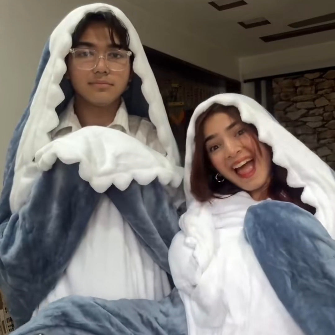 two young adults side by side in matching sharks, faces in the mouths, laughing