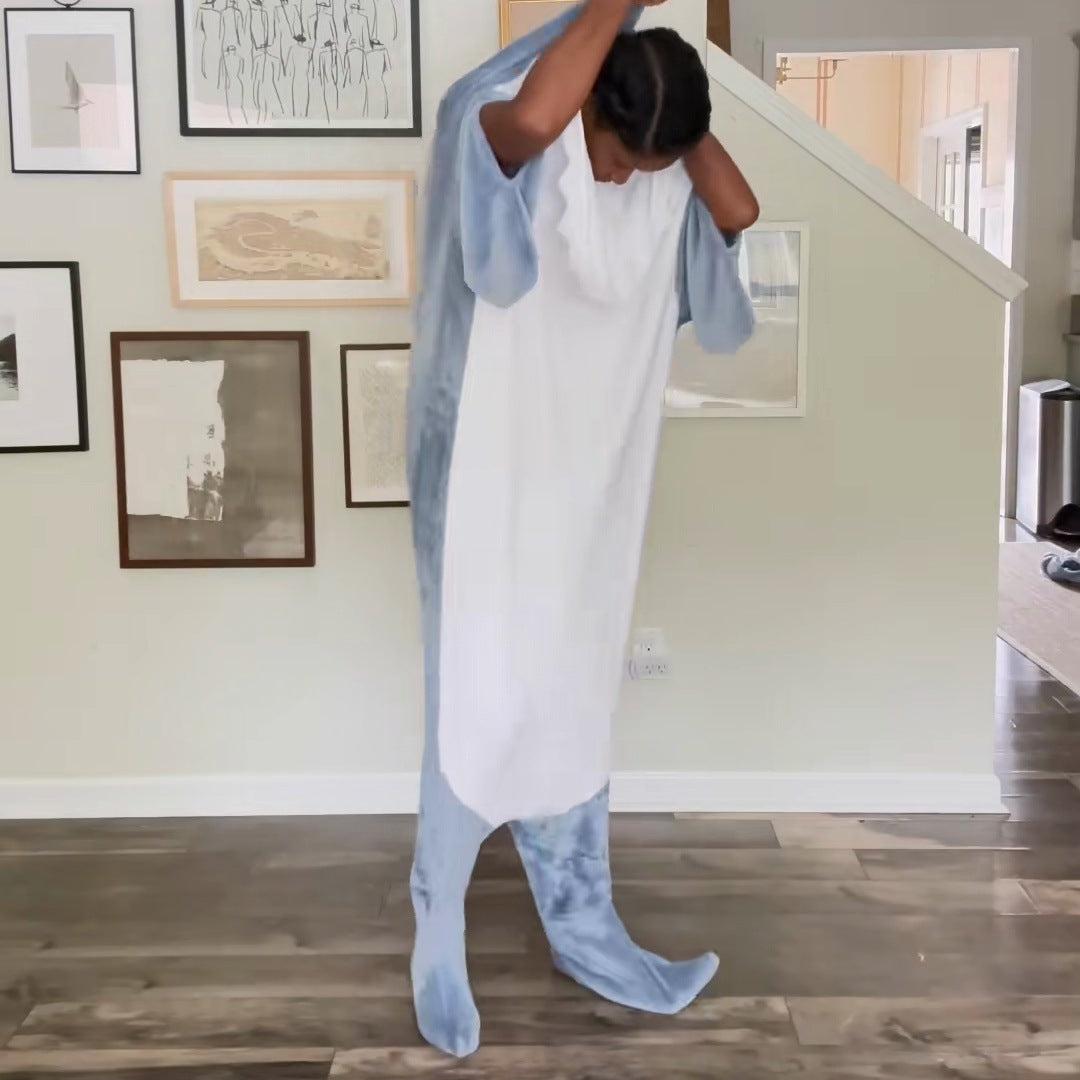 frame 11.0 s of r03: a woman standing in her hallway with her feet in the tail, pulling the shark head up over her hair as a hood