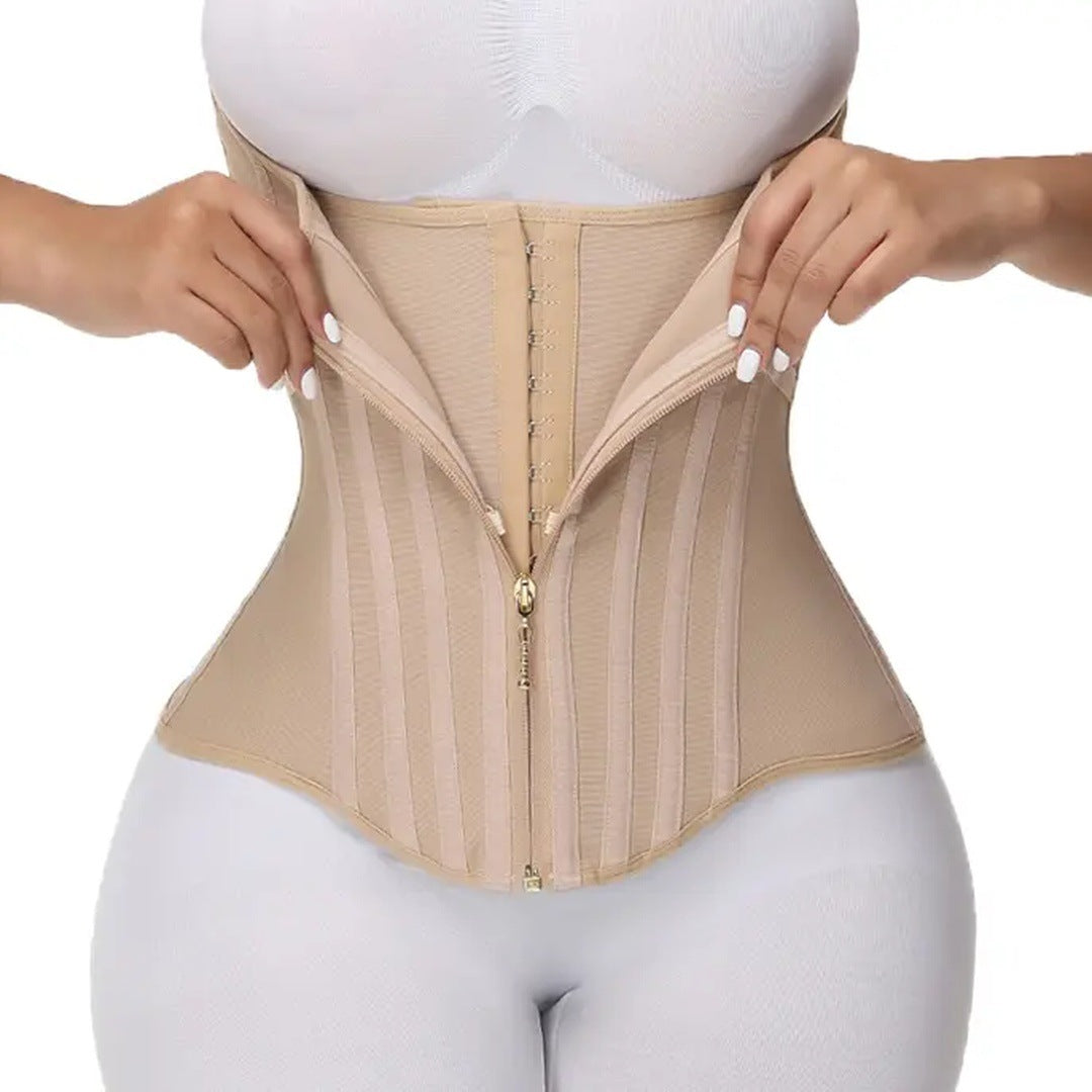The beige corset worn on the torso, hands opening the zipper to show the hooks inside.