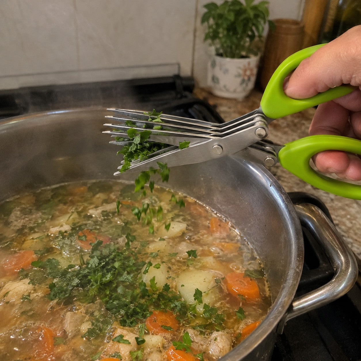 Herbs snipped into a simmering pot of soup