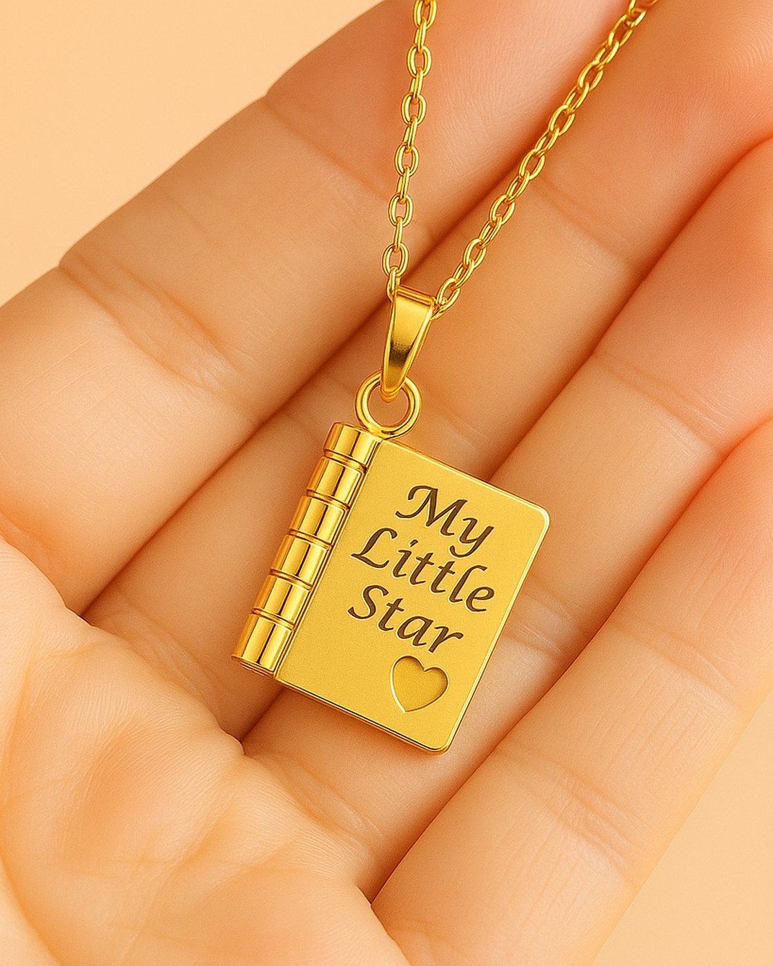 The Pomence My Little Star Book Locket Necklace in Gold held in an open palm