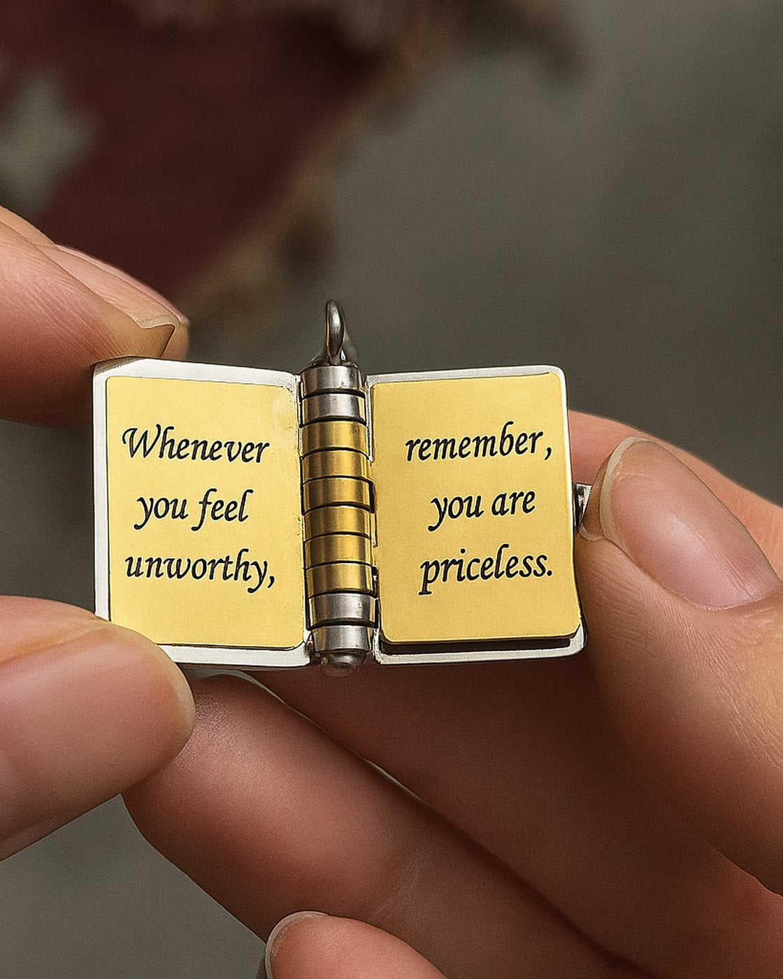 The locket held open at the pages Whenever you feel unworthy, remember, you are priceless