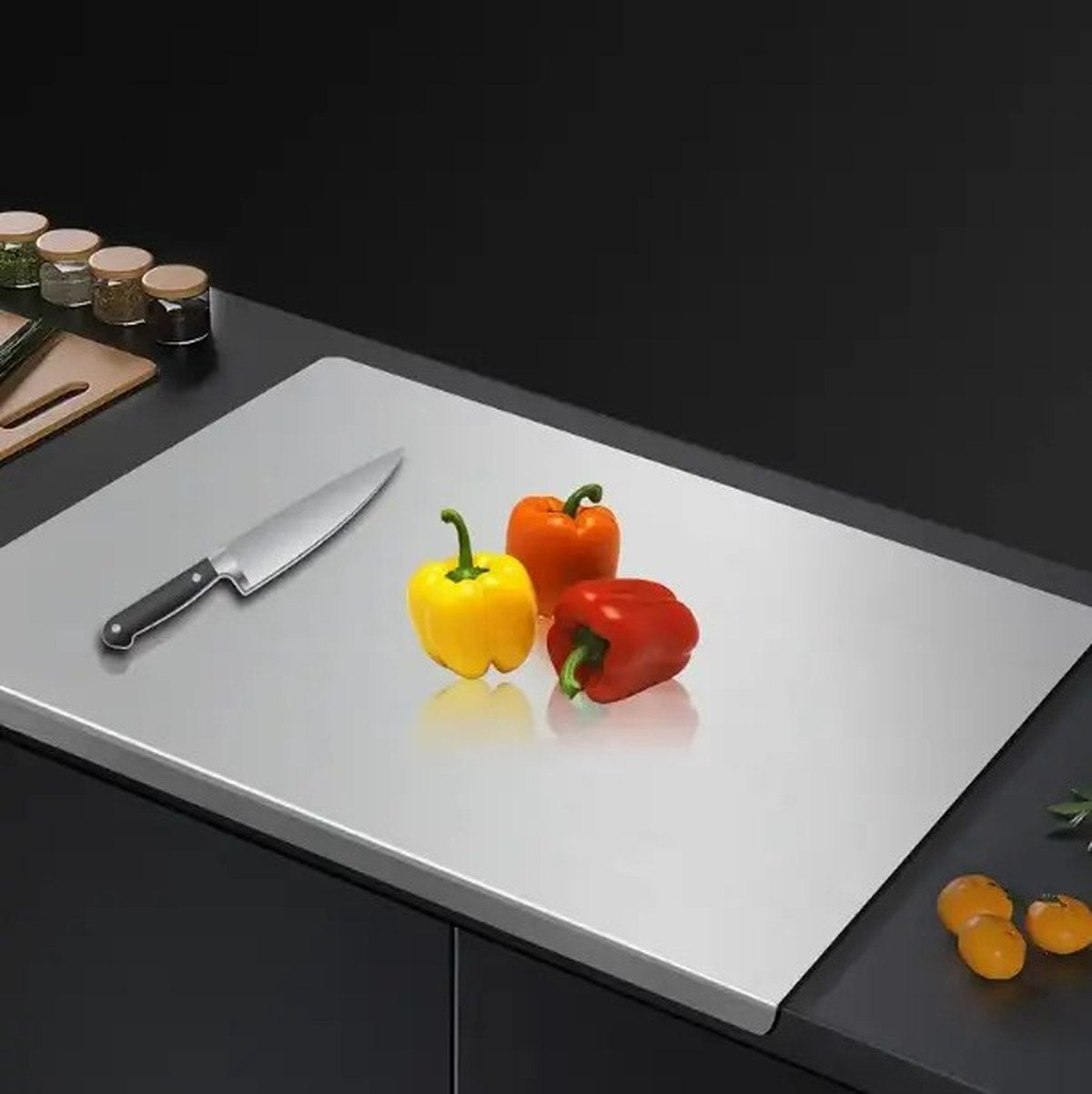 Pomence Stainless Steel Chopping Board on a kitchen counter with a chef knife and peppers