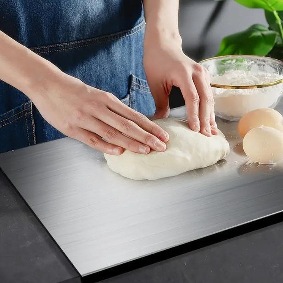 Hands kneading dough directly on the Pomence Stainless Steel Chopping Board