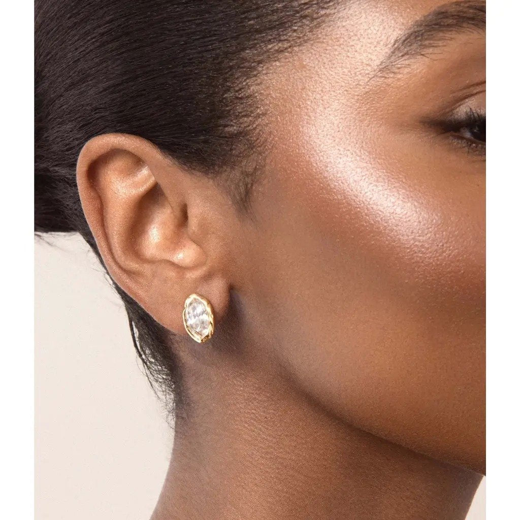 The Pomence Crystal Mini Stud Earrings in clear crystal, worn on the ear through the day
