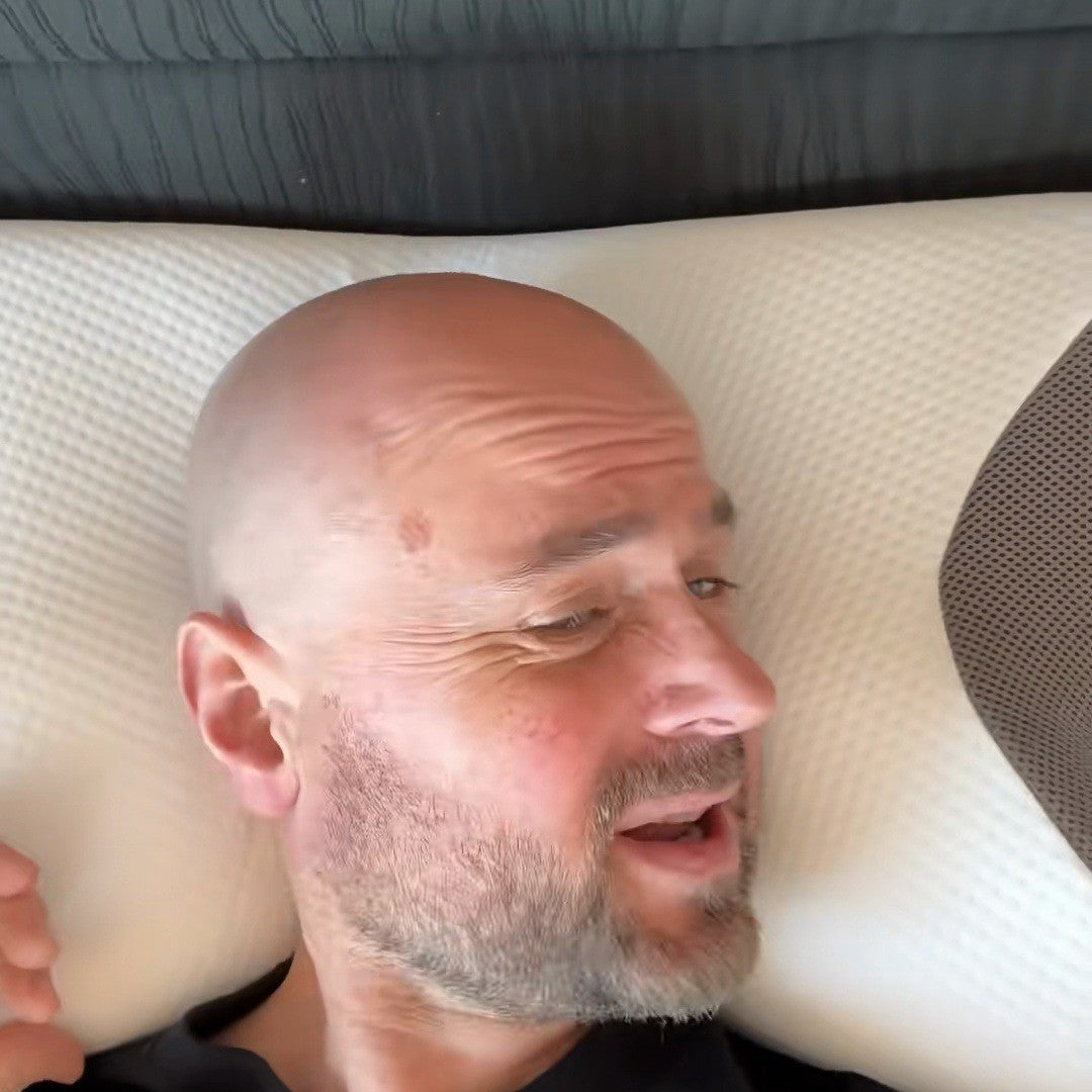 Bald man resting his head level on the pillow in bed