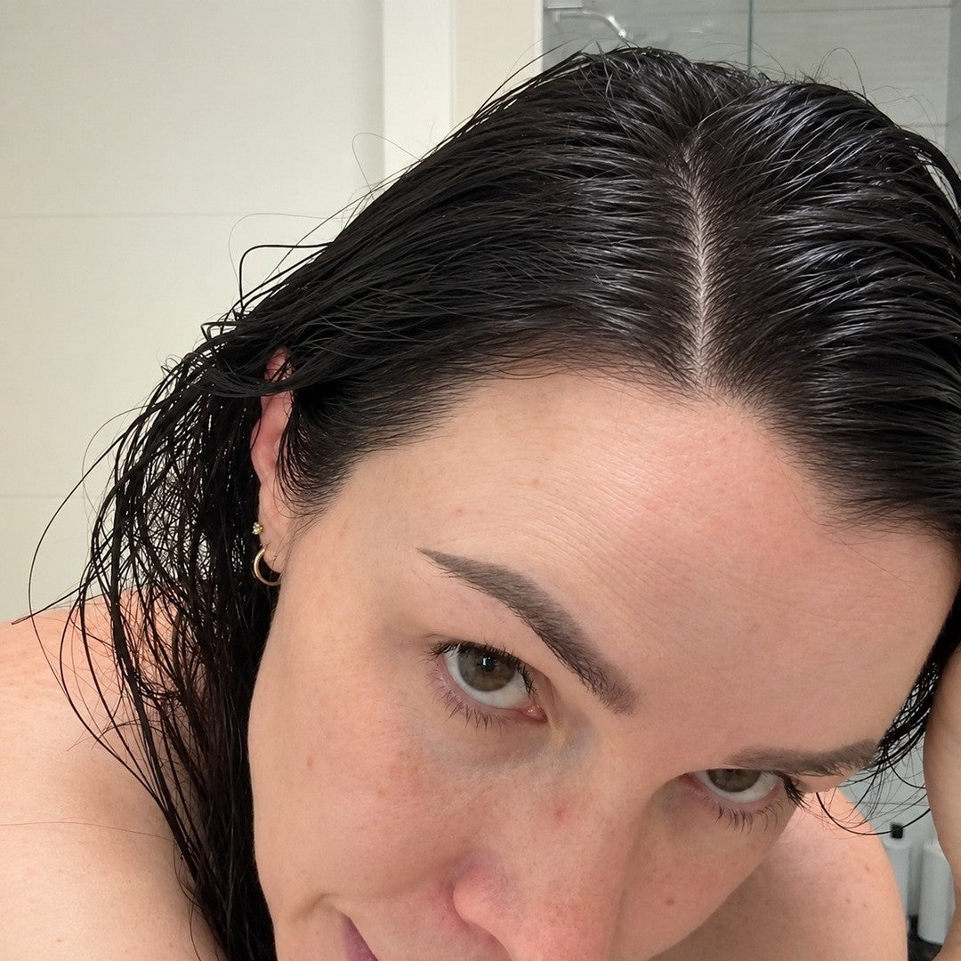 Close-up of a dark, even center part with no gray