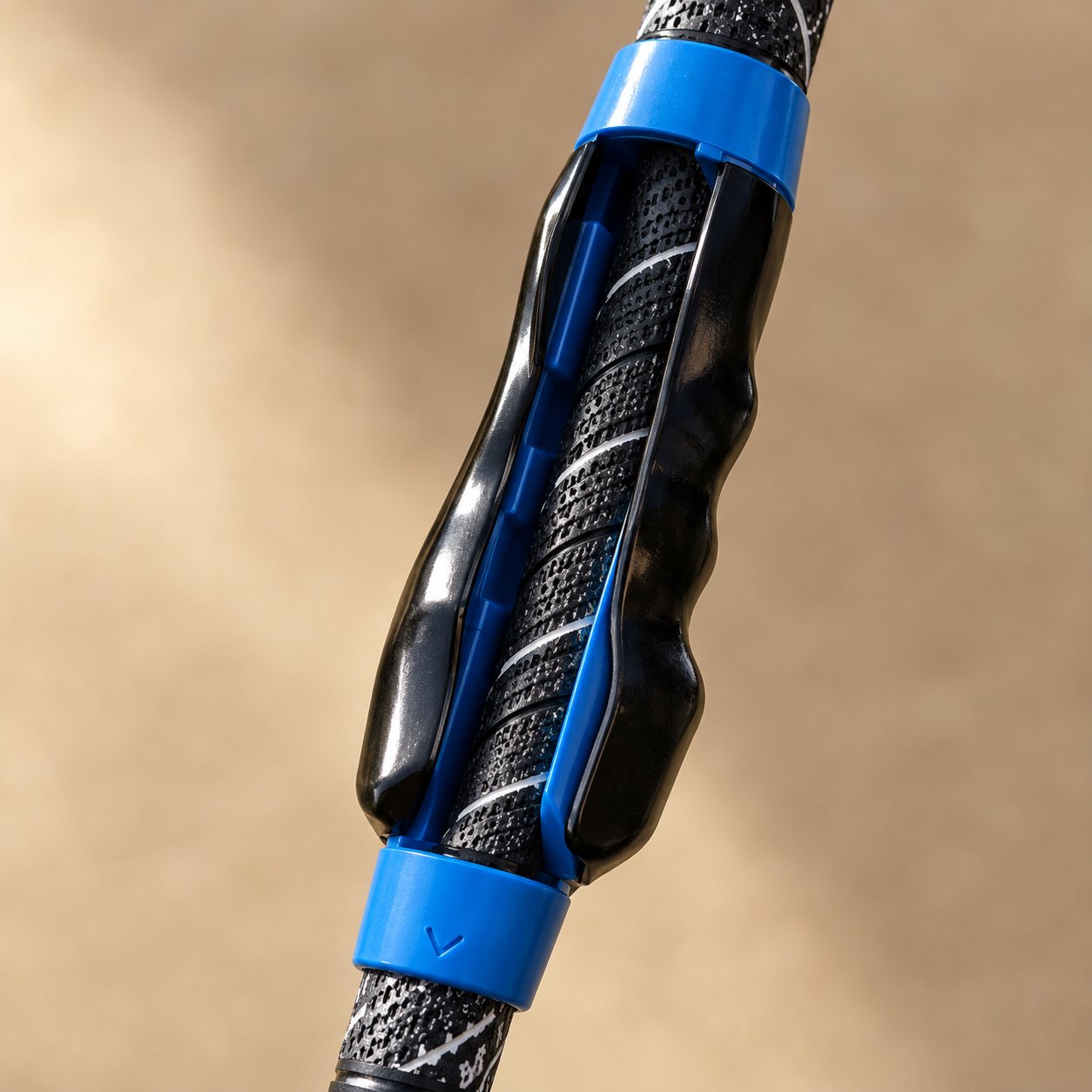 Macro view of the small stamped alignment arrow on the colored end collar of the grip trainer