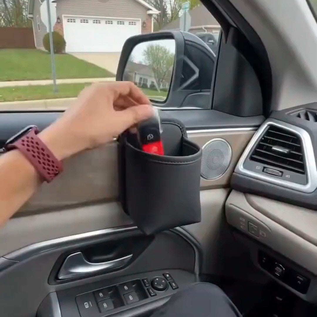 Driver's hand reaching into a black pocket on the door