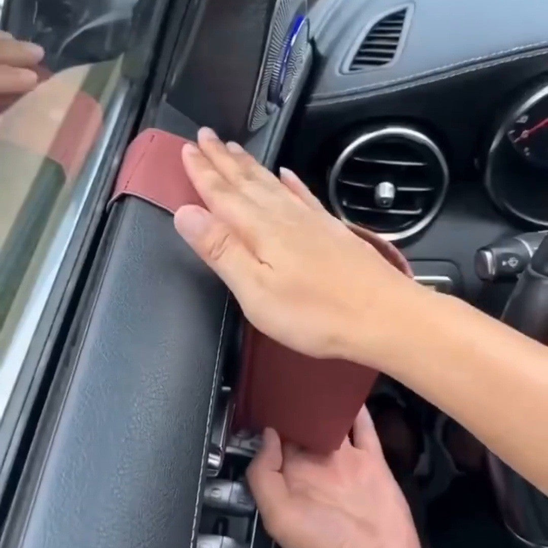 Hands pressing a red pocket onto a door under the window