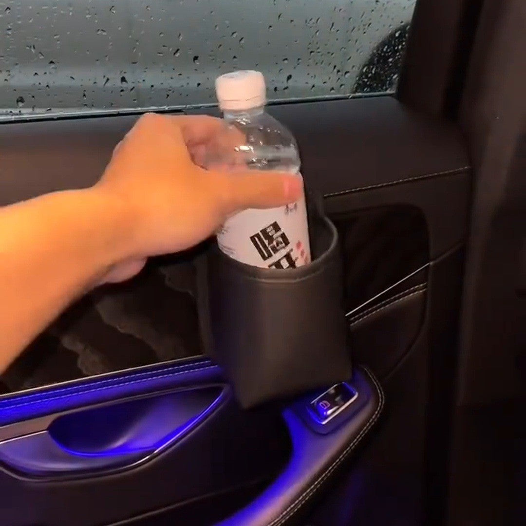 Hand dropping a bottle into a black door pocket