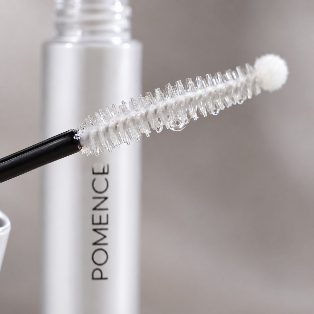 Macro of the curved white C-curl spooly brush of the Pomence serum wand