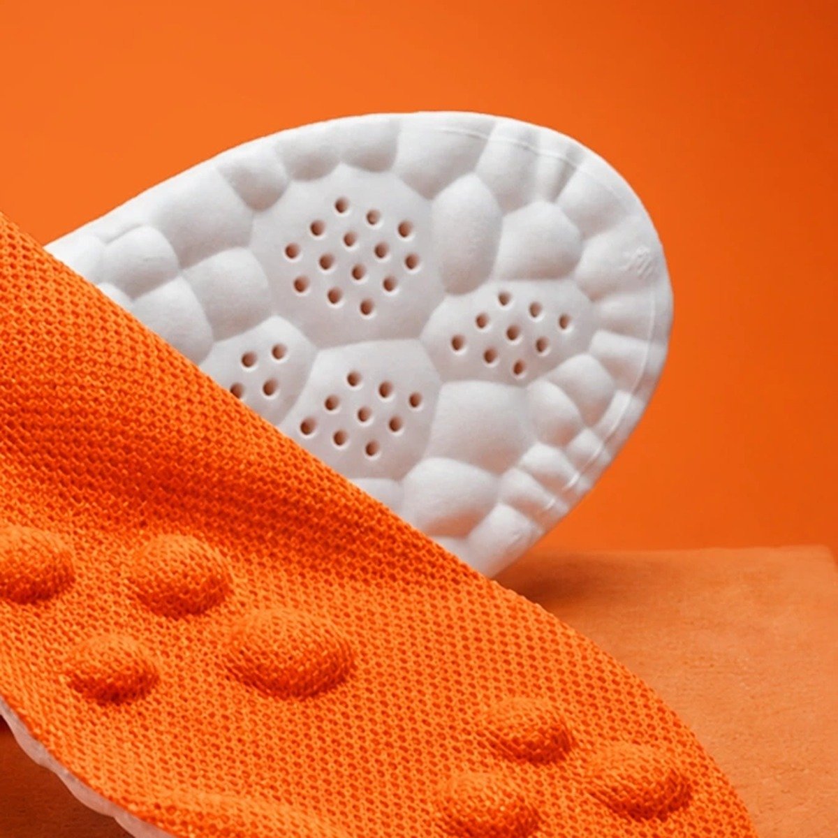 The white cobblestone base of the Pomence Massage Insoles with its vent-hole clusters and deep heel cup