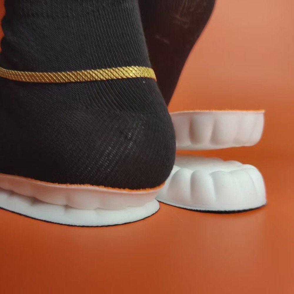Close-up of the raised massage nodes on the orange knit deck of a Pomence Massage Insole