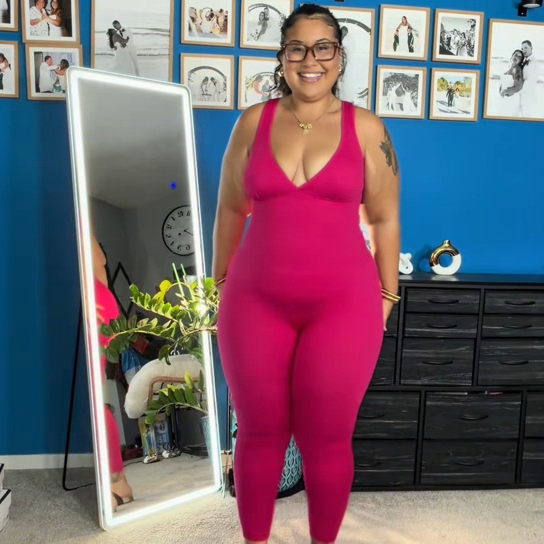 Woman in glasses wearing the Rose Red jumpsuit at home