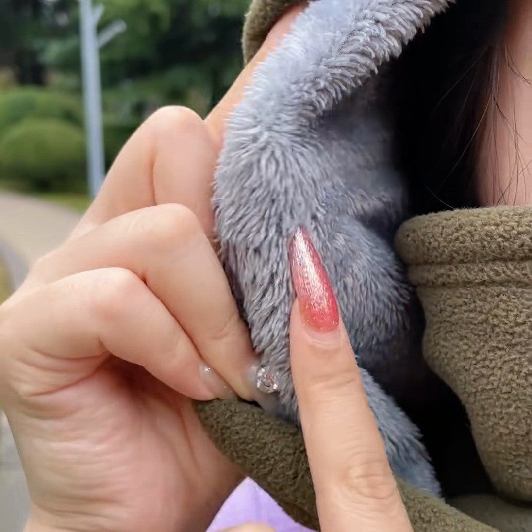 Fingers pinch the thick gray plush inside the face cover