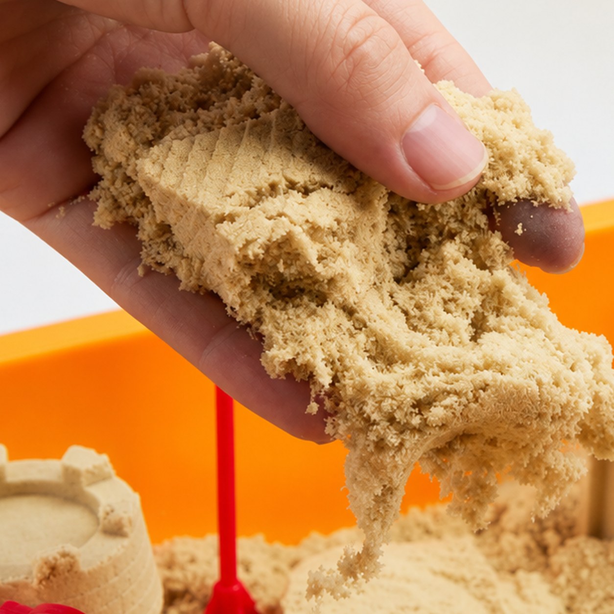 A ball of the soft play sand held in an open palm