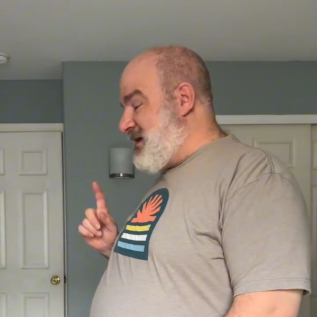 Man on a rooftop in a gray tee over the tucked tank