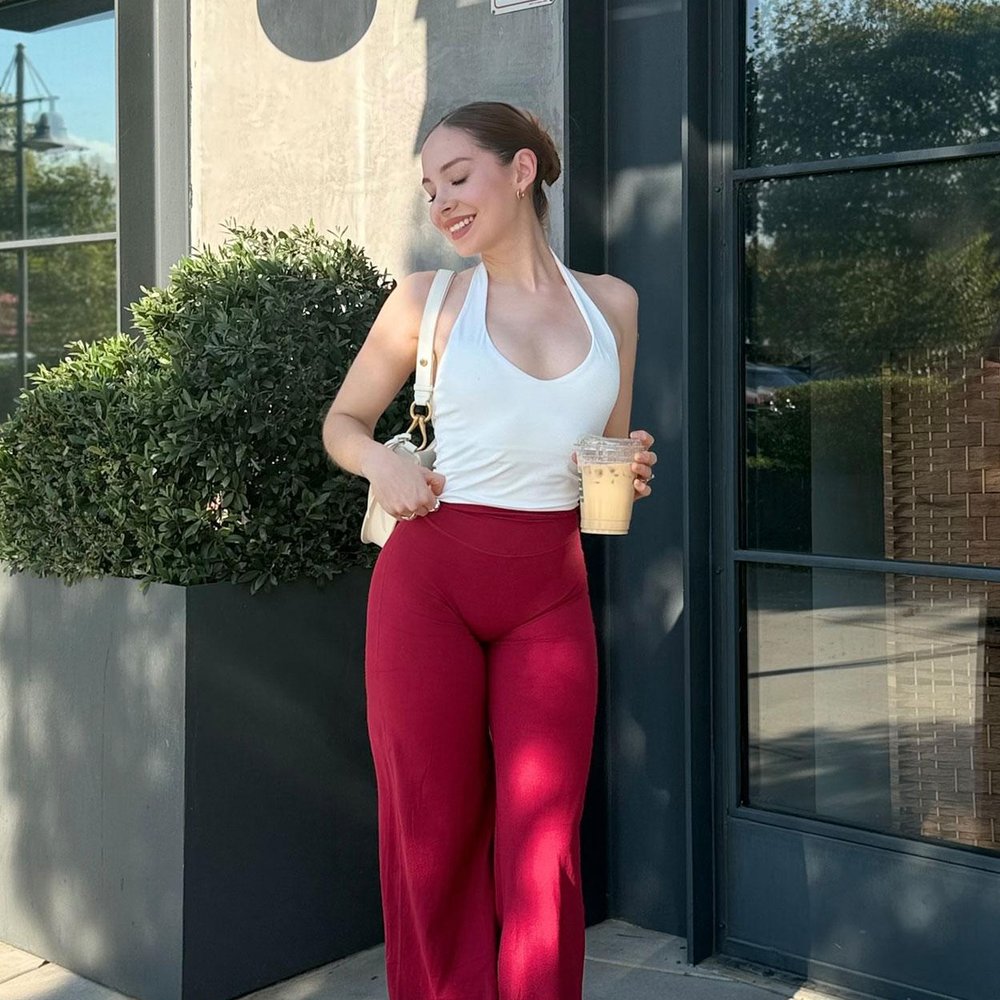 A woman standing outside a cafe in red Pomence straight leg yoga leggings